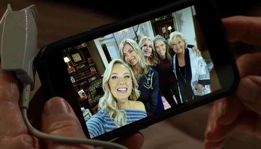 Y&R Scoop: Jack looks at a photo of Abby, Ashley, Lauren, Diane and Traci on his phone