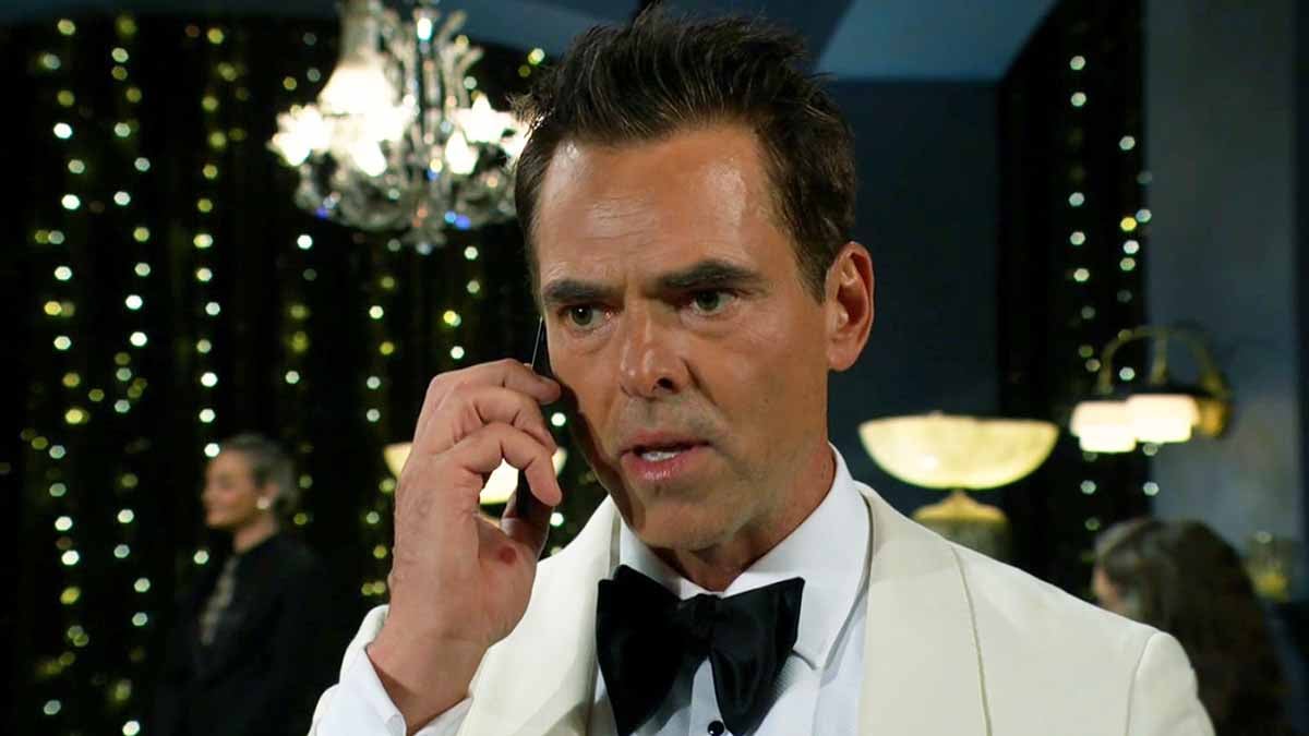 Billy looking devastated while holding a cell phone on Young and the Restless